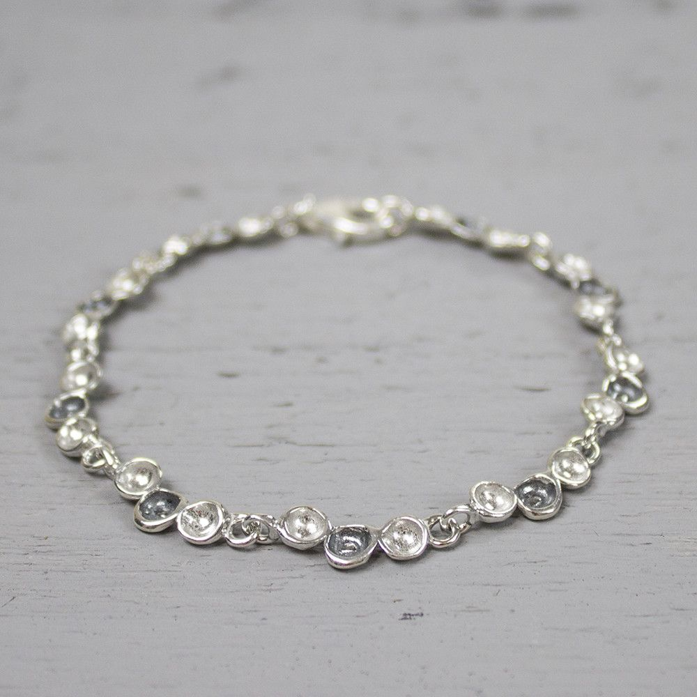 Deze armband behorend bij collier 19437 en is evenals het collier uit de collectie van 2004. De armband bevat schakels bestaande uit drie druppels, waarvan de middelste geoxideerd is.