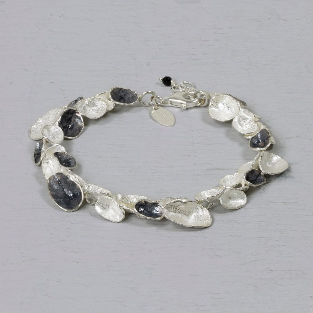 Deze armband van Jéh Jewels is gemaakt van 925 sterling wit zilver met geoxideerd zilver. Deze organische ronde armband, past door de combinatie van de twee kleuren bij verschillende colliers uit de Jéh collectie.